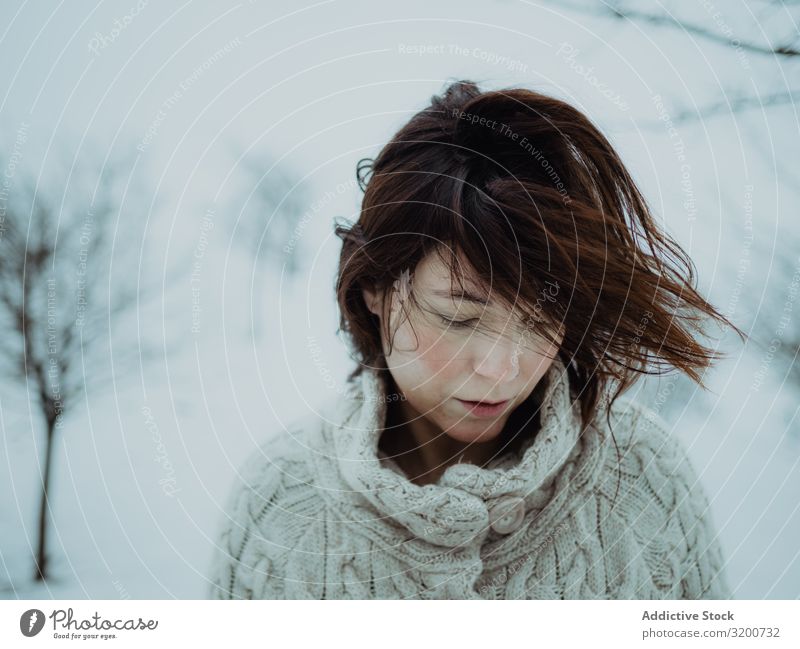 Verträumte Frau im Pullover gegen die Winterlandschaft Porträt Landschaft träumen Schnee brünett besinnlich Model weiß Gegend attraktiv Jahreszeiten kalt Stil