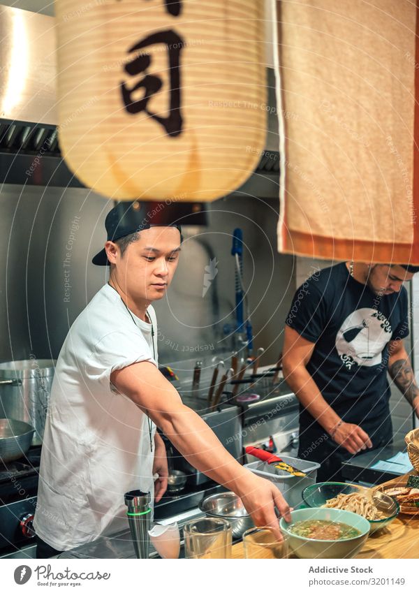 Junge Männer arbeiten in der Küche Mann kochen & garen Ramen Lebensmittel Beruf Japaner Speise Restaurant Arbeit & Erwerbstätigkeit Person gemischter Abstammung