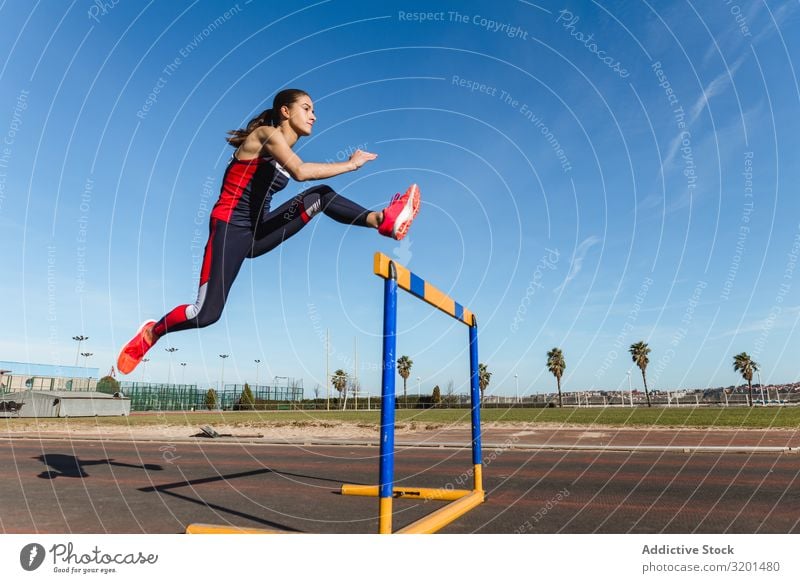 Sportlerinnen beim Hürdenlauf im Stadion Frau springen Bahn Jugendliche Sportbekleidung Himmel blau Konkurrenz Athlet Tatkraft Motivation anstrengen stark Kraft