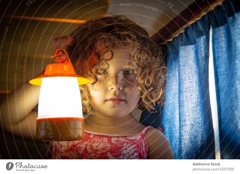 Hübsches Mädchen mit Taschenlampe klein Fackel Kind spielerisch Verstand Etage Horrorgeschichte aussagekräftig Spielen Mensch niedlich reizvoll krause Haare