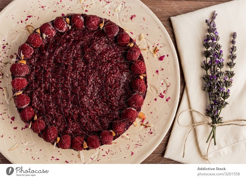 Fruchtbeerkuchen und Lavendelzweig auf dem Tisch Kuchen Vegane Ernährung Himbeeren Lebensmittel Dessert süß frisch rot lecker Beeren gebastelt Backwaren