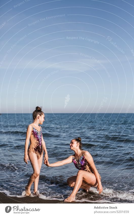 Weibliche Turnerinnen halten sich auf dem Meeresgrund an den Händen Frau rhythmisch Athlet Sport Pose Turnen Jugendliche Mädchen Mensch sportlich dünn Anmut