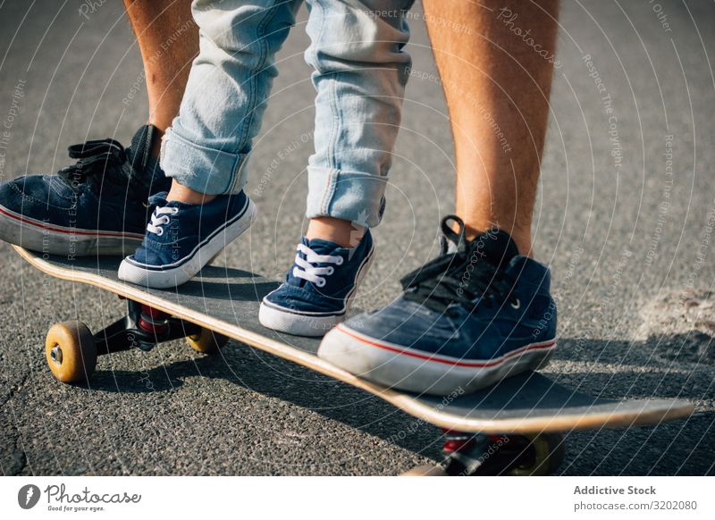 Mann mit Kind trainiert mit Skateboard auf Asphalt Vater genießend Elternschaft laufen Ferien & Urlaub & Reisen Familie & Verwandtschaft Lehre Zusammensein