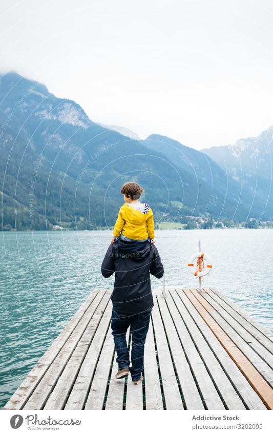Mann mit Kind im Nacken geht am Pier entlang Vater Elternschaft Landschaft Anlegestelle laufen Natur Ferien & Urlaub & Reisen Familie & Verwandtschaft