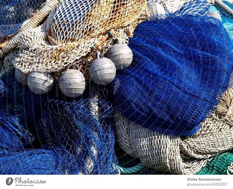 Blaue und beige Fischernetze mit Auftriebshilfen auf Sardinien Fischfang Netzwerk Fischereiwirtschaft Hafen Maschen Angeln Fischereihafen Kai trocknen Lagerung