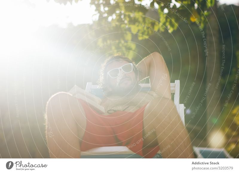 Mann chillt auf Liegestuhl bei Sonnenschein Kälte Ferien & Urlaub & Reisen Sommer Thailand Sonnenlicht Buch Erholung Freizeit & Hobby Sonnenbank Badeanzug