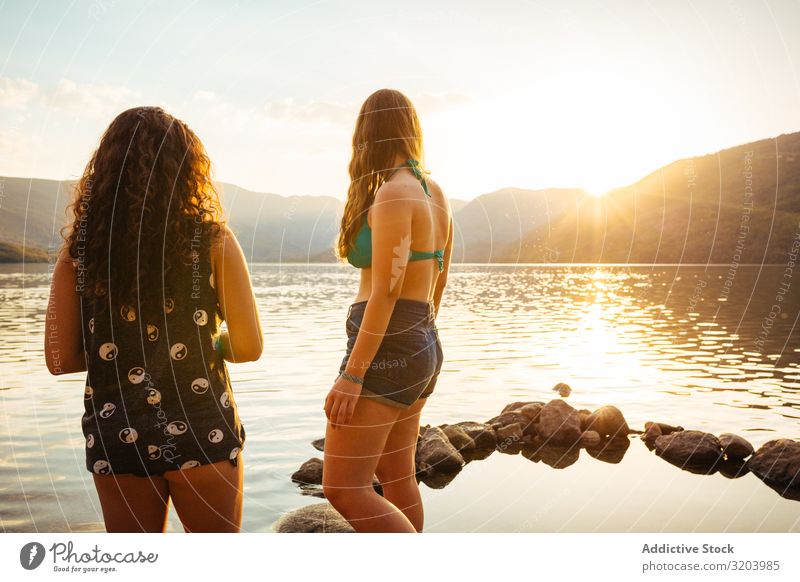 Frauen an der Küste im Sonnenuntergangslicht Freundin Badeanzug Sommer Ferien & Urlaub & Reisen Strand Zusammensein Jugendliche Natur Wasser Erholung Frieden