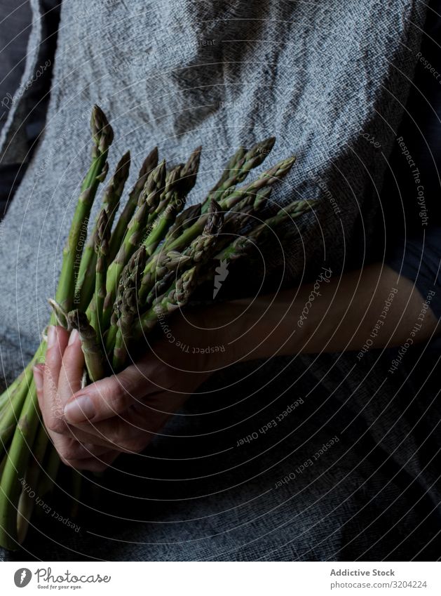 Gesichtslose Frau mit einem Bündel grünen Spargels rustikal Hand Halt organisch Diät Lebensmittel natürlich Ernährung roh Zutaten Vegetarische Ernährung zart