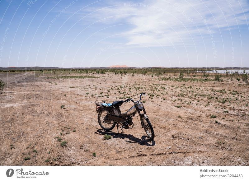 Motorrad in weitläufigem Wüstengelände Gelände Tourismus Marokko Sand Fahrrad Wege & Pfade Bahn Landschaft abgelegen Einsamkeit Boden Sonnenlicht heizen Himmel