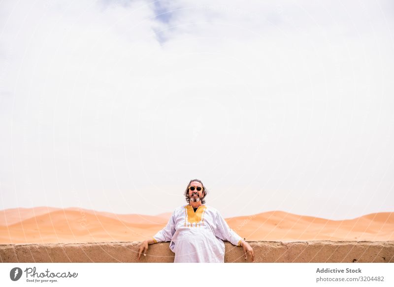 Fröhlicher erwachsener Mann in der Wüste Porträt Blick in die Kamera anlehnen Balkon Marokko Ferien & Urlaub & Reisen Aussicht Landschaft heizen exotisch