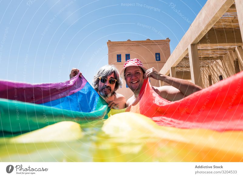 Glückliches schwules Paar im Schwimmbad Homosexualität lgbt Fahne Übergewicht Zusammensein Liebe Resort Ferien & Urlaub & Reisen Wasser Mann versteckend