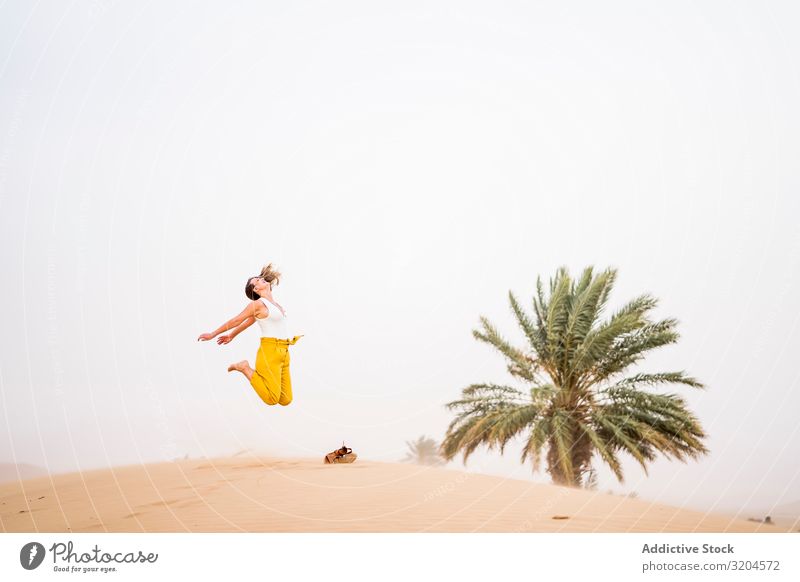 Glückliche Frau springt in der Wüste heiter Ferien & Urlaub & Reisen Stil Gast Marokko trendy Freude Sommer Beautyfotografie abgelegen blond Zufriedenheit schön