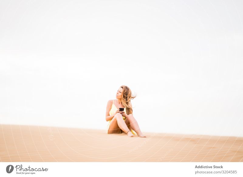 Glückliche Frau mit Smartphone in der Wüste heiter Mitteilung Handy Technik & Technologie Ferien & Urlaub & Reisen Stil Gast Marokko Freude Sommer