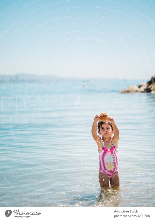 Süßes Mädchen spielt im Wasser der Küste Spielen Muschel Seeküste niedlich Kleinkind reizvoll Meer Badeanzug Wärme Strand Sonnenstrahlen Kindheit