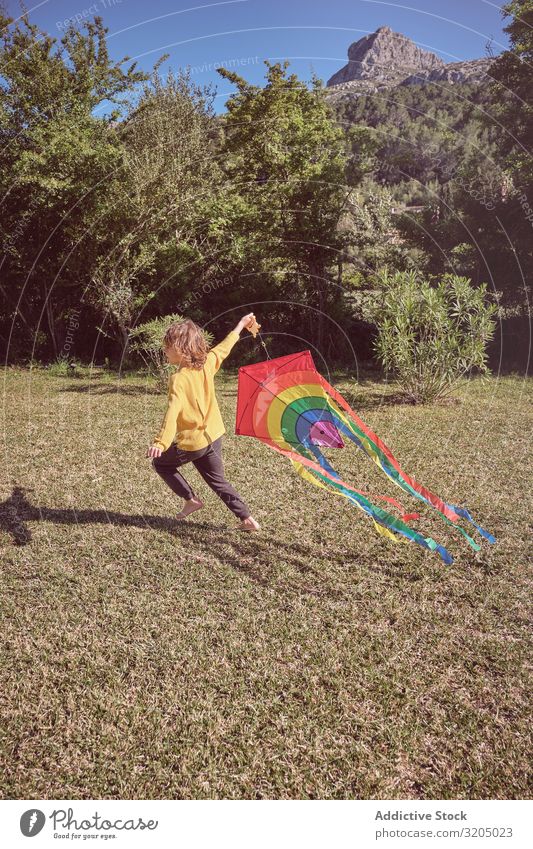 Junge startet Drachen am Sommertag Lenkdrachen Himmel Freude Kindheit Spielen fliegen Landschaft klein Mensch Aktion spielerisch lässig Unbekümmertheit heiter