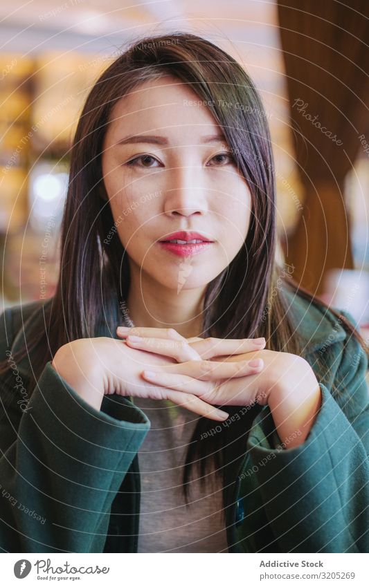 Porträt einer jungen asiatischen Frau, die in die Kamera schaut Café Tisch sitzen Jugendliche Blick in die Kamera zugänglich genießen Lifestyle Freizeit & Hobby