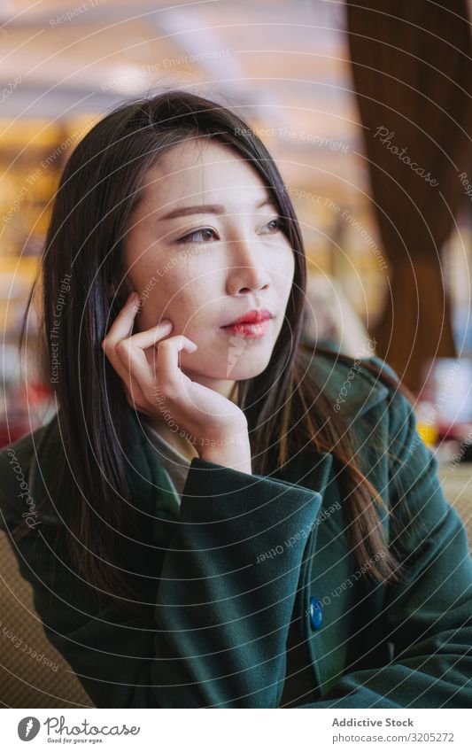 Porträt einer jungen asiatischen Frau, die wegschaut Café Tisch sitzen Jugendliche genießen Lifestyle Freizeit & Hobby ruhen Erholung urwüchsig Stil trendy