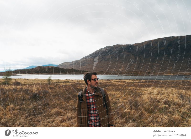 Reisender Mann im abgelegenen kalten Tal reisen Schottland Berge u. Gebirge Abenteuer Rucksack Trekking erkunden Natur Urlaub Landschaft See Freiheit Fernweh