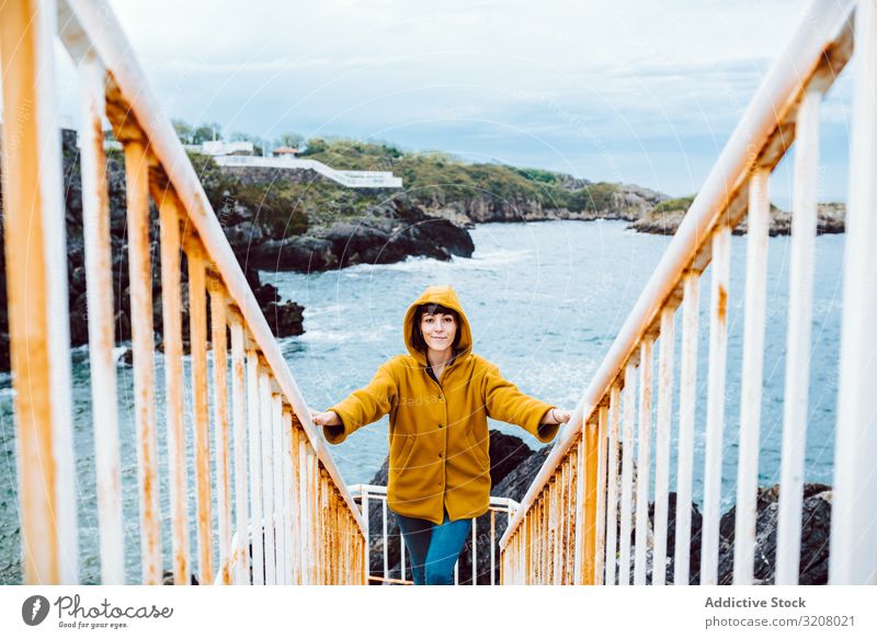 Frau steht auf Stufen in der Nähe des Meeres MEER Ufer Treppenhaus Bucht Wellen Wasser rostig Reling reisen Ausflug Tourismus Reise lässig Küste Unwetter Wetter