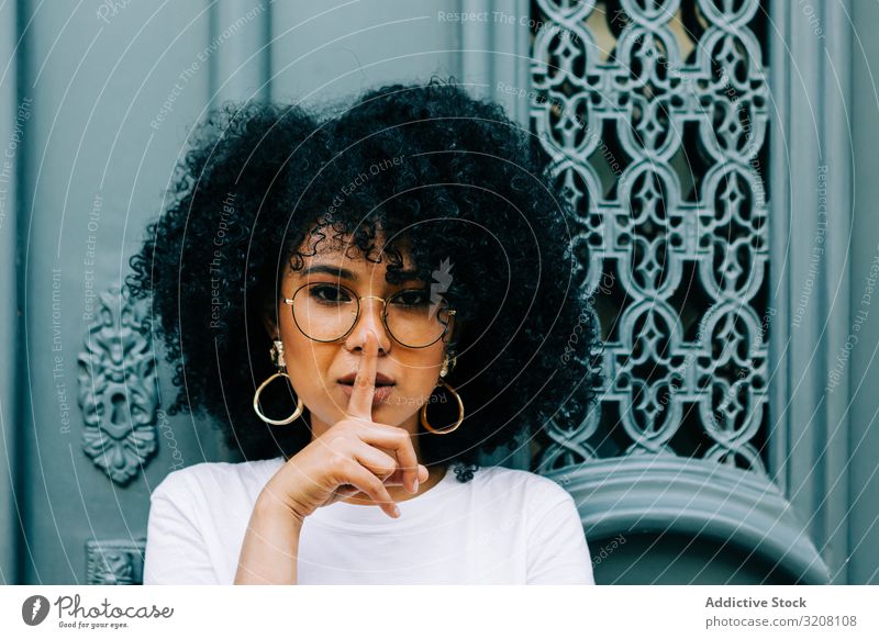 Stilvolle Afroamerikanerin bei grüner Tür bittet um Ruhe Frau Schwelle stylisch trendy lässig Frisur ethnisch jung Person ernst besinnlich attraktiv schön