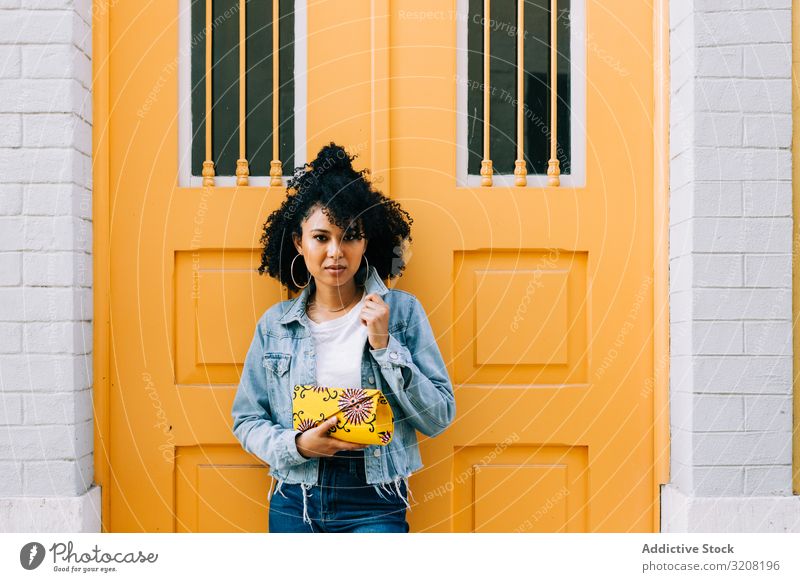 Stilvolle ethnische Frau bei gelber Tür Bogen stylisch trendy Architektur reisen Tourismus Ausflugsziel jung Afroamerikaner lässig besinnlich attraktiv schön