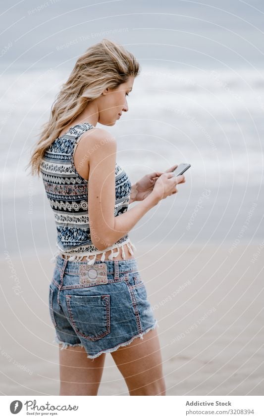 Hübsche Frau beim Telefonieren mit dem Handy Smartphone MEER Strand sprechend Sommer Urlaub reisen Mitteilung Feiertag jung attraktiv schön blond lässig