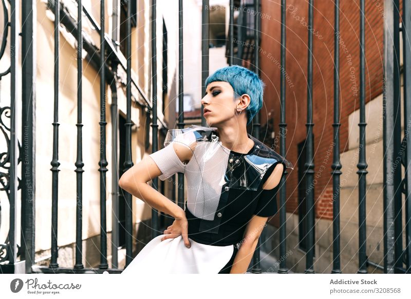 Selbstbewusste Frau in futuristischer Kleidung auf der Straße Großstadt trendy Model Kontrast selbstbewusst Gebäude Straßenbelag Hände an der Taille jung Stil