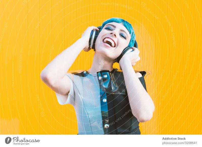 Coole informelle Frau mit Kopfhörern auf der Straße Musik Smartphone Generation heiter Ausdruck pulsierend urban hören futuristisch Subkultur Melodie Lächeln