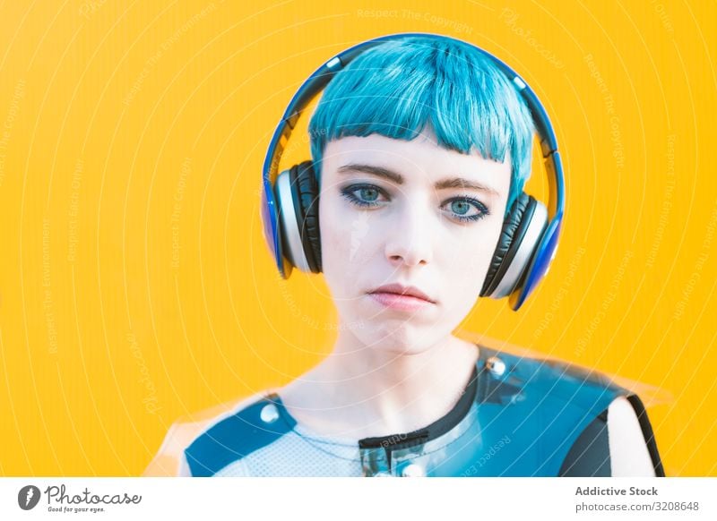 Coole informelle Frau mit Kopfhörern auf der Straße Musik Smartphone Generation heiter Ausdruck pulsierend urban hören futuristisch Subkultur Melodie Lächeln