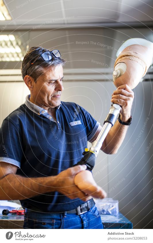 Mann, der eine Prothese in einer Werkstatt repariert Arbeiter Nachahmung Einstellung Medizin künstlich Objekt Prothesen Industrie Fußknöchel Gesundheitswesen