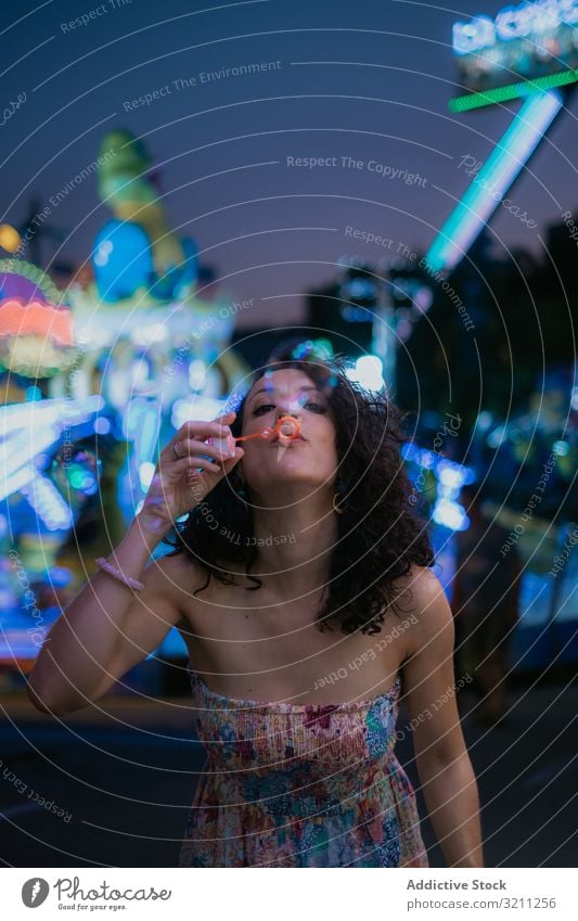 Frau im Vergnügungspark bläst Blasen Schaumblase Schlag Sommer Spaß Freizeit brünett genießen jung Abend schön Feiertag Urlaub Anziehungskraft unterhalten
