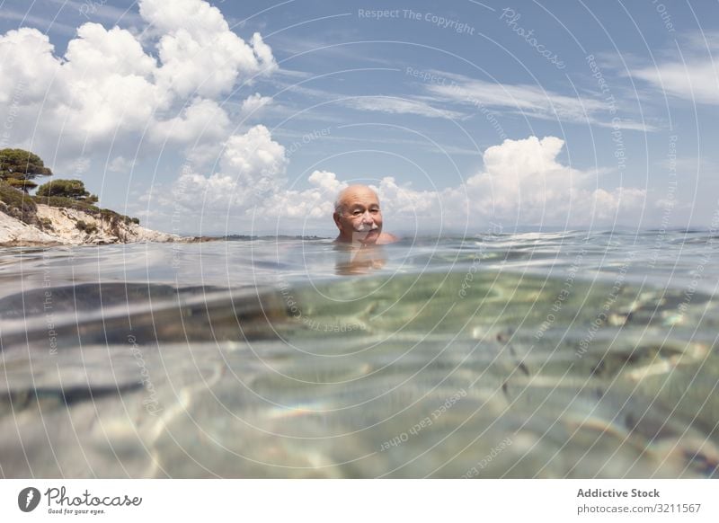 Fröhlicher älterer Mann schwimmt im Meerwasser Schwimmsport Urlaub Senior Kristalle in den Ruhestand getreten reisen Freizeit Wasser MEER Griechenland halkidiki
