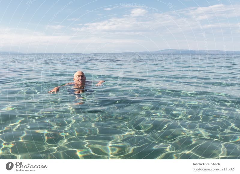Älterer Mann mit Schnurrbart schwimmt in klarem Wasser Schwimmsport MEER in den Ruhestand getreten Urlaub Senior Griechenland halkidiki Meer marin Kristalle