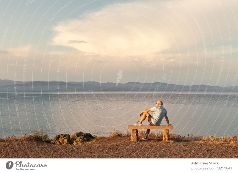 Mann sitzt auf einer Bank und genießt den Blick aufs Meer Meereslandschaft Urlaub Gelassenheit erstaunlich Landschaft MEER beobachten Wasser Sommer Strand