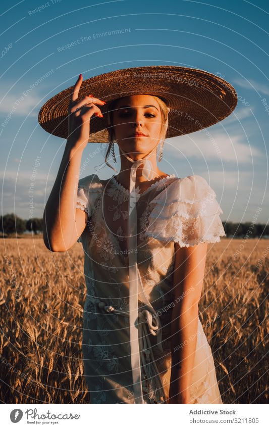 Frau mit großem runden Hut inmitten eines Weizenfeldes Feld Boho Spitze schön Stil Angebot Braut sinnlich natürlich Sommer romantisch Hochzeit blond Stroh