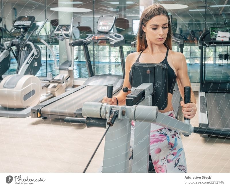 Starke Frau auf Reihenmaschine Übung Maschine Fitnessstudio Training Sport Athlet Stärke Kraft Rücken modern passen jung Gesundheit Wellness Wohlbefinden