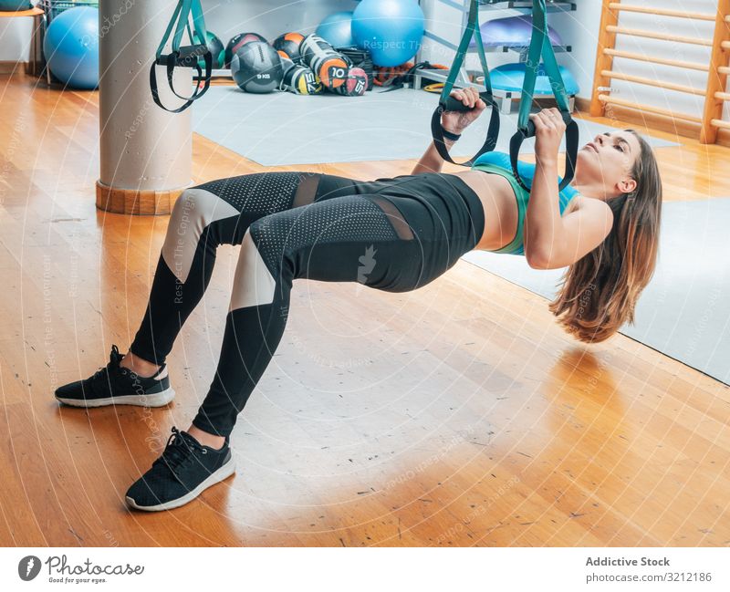 Training junger Frauen in der Turnhalle Sportlerin Suspension Seil Übung trx Körpergewicht erhängen physisch Athlet Fitnessstudio Motivation Stärke Kraft modern