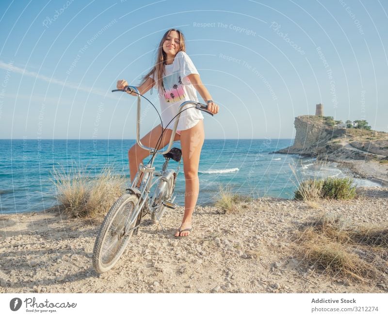 Frau radelt auf Sandstrandhügel Fahrrad sandig Seeküste Urlaub Glück Fahrradfahren Sommer winken aktiv Lifestyle Feiertag Ausflug energetisch reisen Reise jung