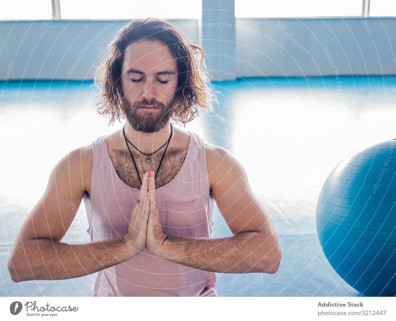 Männlich meditierend im geräumigen Raum Mann Fitnessstudio Lotos sich[Akk] entspannen Yoga Vitalität Zen Harmonie Übung Asana Sport Beine gekreuzt jung