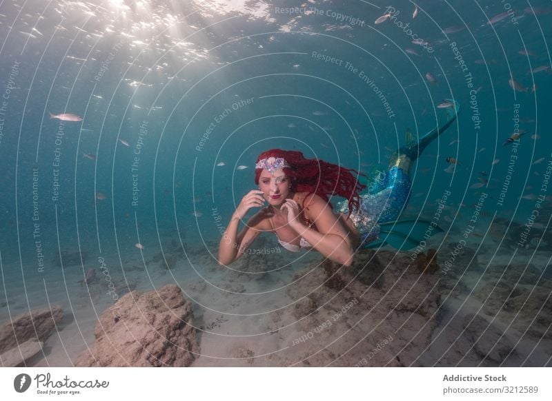 Rothaarige märchenhafte weibliche Meerjungfrau schwimmt unter Wasser Fisch schwimmen verträumt Fischschwanz Sonnenstrahlen blau MEER tief schön Tageslicht