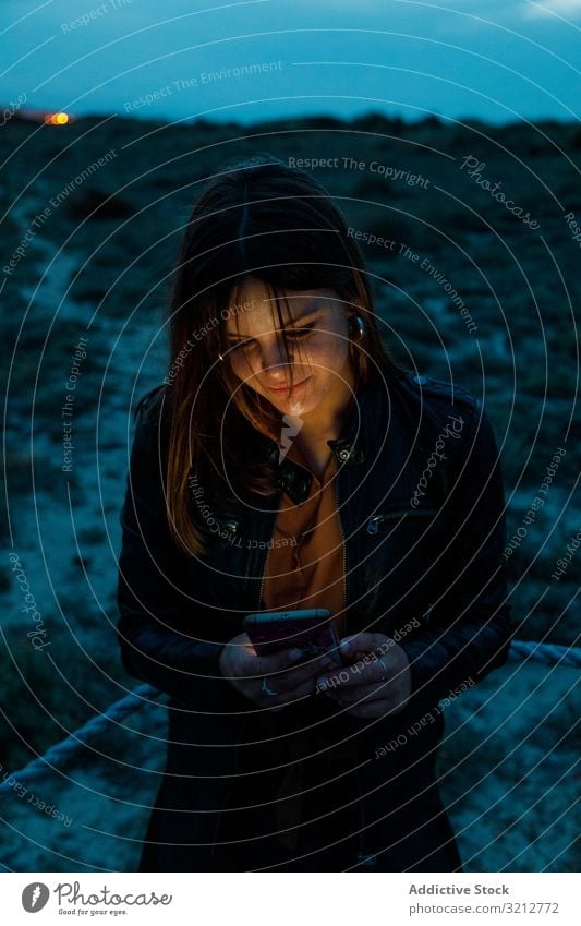 Frau surft mit ihrem Smartphone nachts im Freien Lederjacke Handy Browsen Nacht schön Mitteilung Internet Anschluss jung Nachricht Text Technik & Technologie