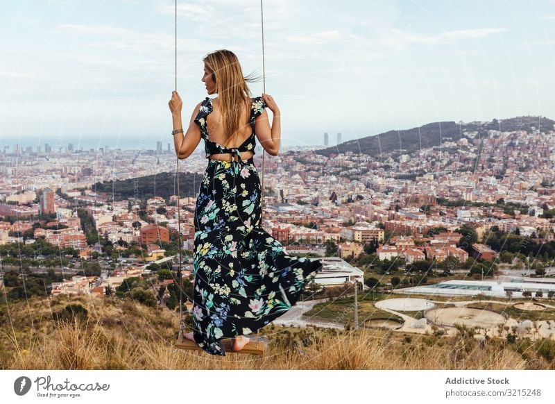 Mädchen von hinten auf einer Schaukel pendeln Frau Himmel Person Sitzen Kleid Natur Großstadt Barcelona Rücken jung Sommer schön swinging im Freien Glück