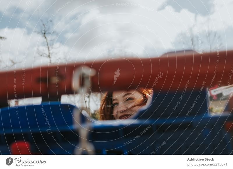 Frau schaut durch das Einkaufswagengitter im Einkaufswagen attraktiv jung schön lässig heiter Lächeln klug Handwagen modern Freude Rotschopf hübsch Vergnügen