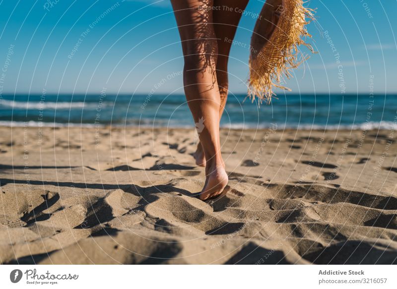 Frauenbeine am Sandstrand Ernte Strand anonym unkenntlich horizontal Rückansicht sandig Badebekleidung Hut Wasser laufen Meer Sommer genießend Freizeit Körper