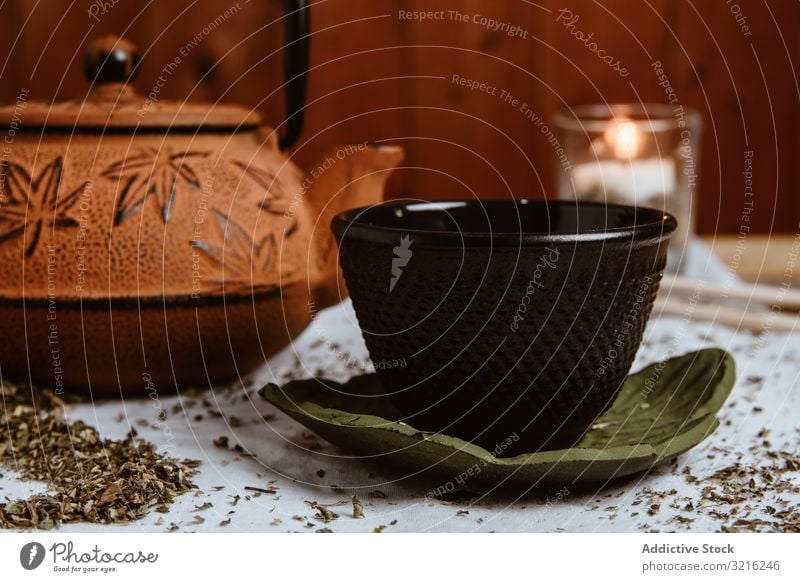 Aromatische Teedatteln und Ton-Teekanne auf dem Tisch Daten Blätter Kräuterbuch trinken grün heiß natürlich traditionell Getränk Schalen & Schüsseln