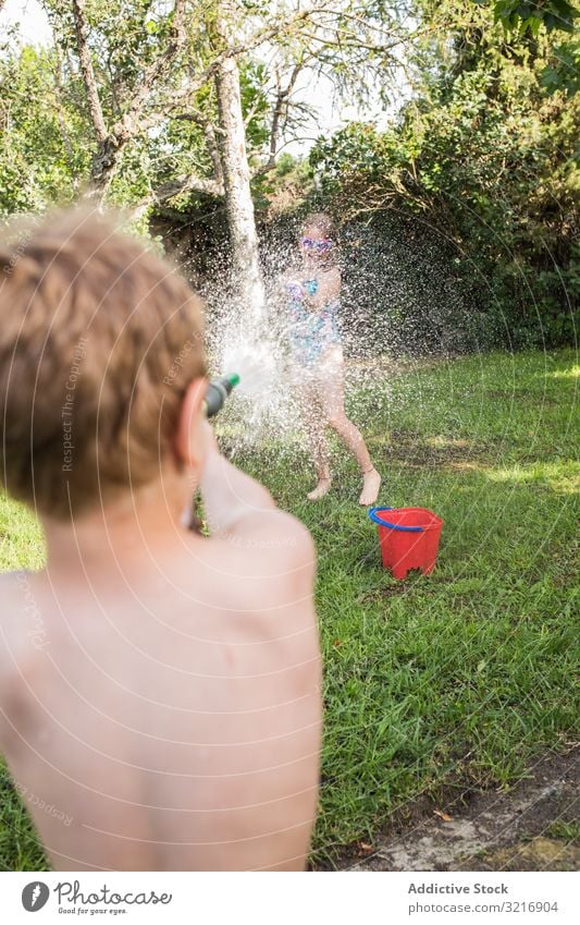 Kleine Kinder in Badebekleidung haben Spaß mit Spritzwasser Geplätscher Wasser Sommer Spielen Glück Lifestyle Freizeit Erholung Feiertag Kindheit Freude Genuss