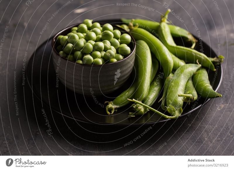 Frische Erbsen und Erbsenschoten auf dunklem Hintergrund Schalen & Schüsseln ökologisch Lebensmittel frisch grün Gesundheit Hülsenfrüchtler natürlich organisch