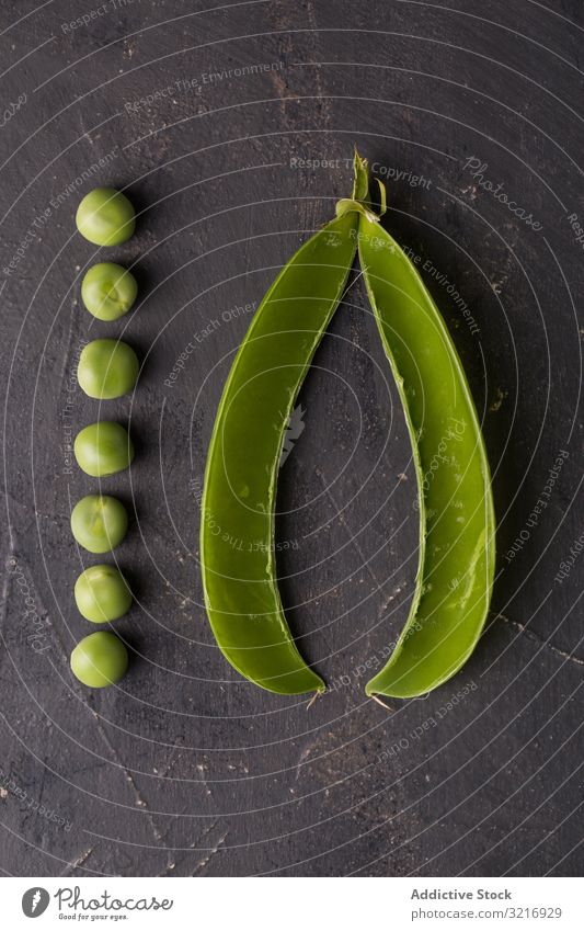 Frische Erbsen und Erbsenschoten auf dunklem Hintergrund ökologisch Lebensmittel frisch grün Gesundheit Hülsenfrüchtler natürlich organisch roh Samen Gemüse