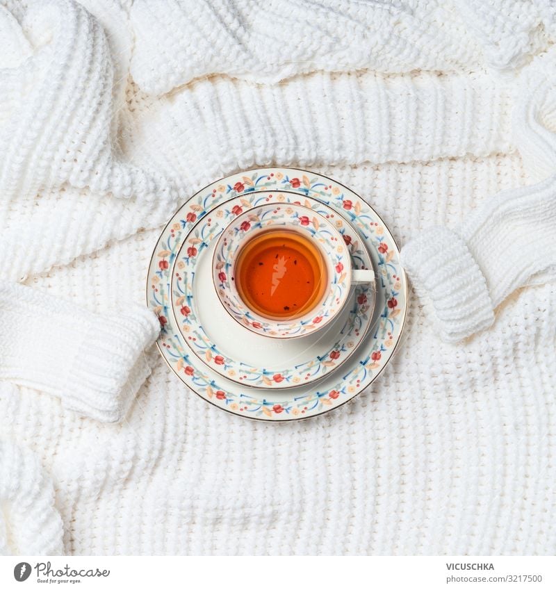 Tasse Tee auf gestrickter Strickjacke Getränk Heißgetränk Lifestyle Stil Design Leben Winter Häusliches Leben Pullover Hintergrundbild weiß Farbfoto