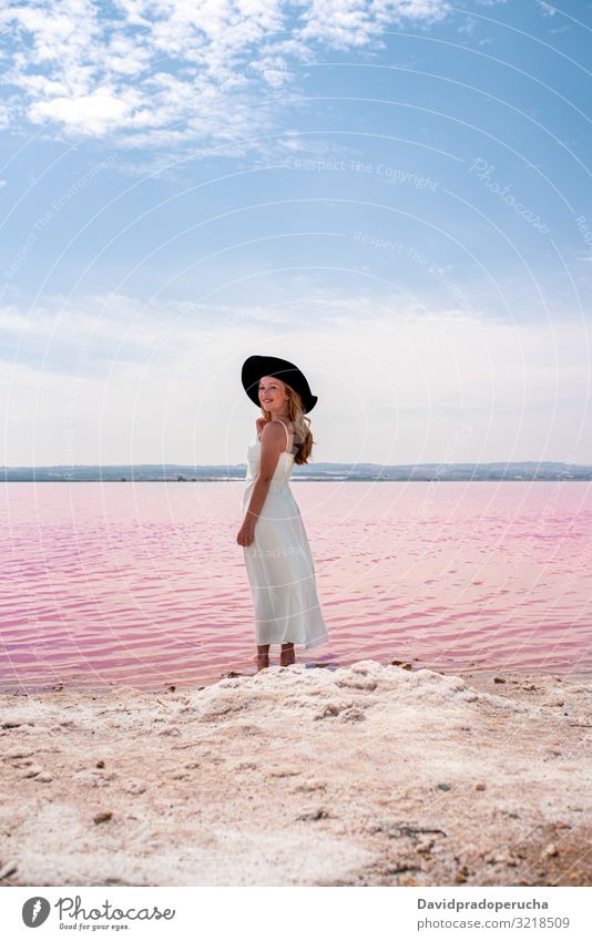 Rückansicht von niedlichen Teenager Frau trägt weißes Kleid zu Fuß auf eine erstaunliche rosa See jung Kochsalzlösung romantisch Tourismus Sommer Glück allein